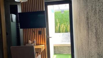 Una habitación moderna con televisión de pantalla plana, una mesa de comedor y una silla.