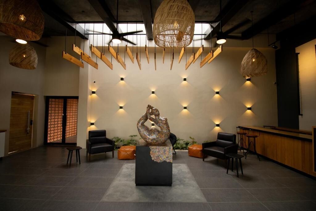 Rebedor amb una escultura central, zona de seients i una taquilla d'informació.