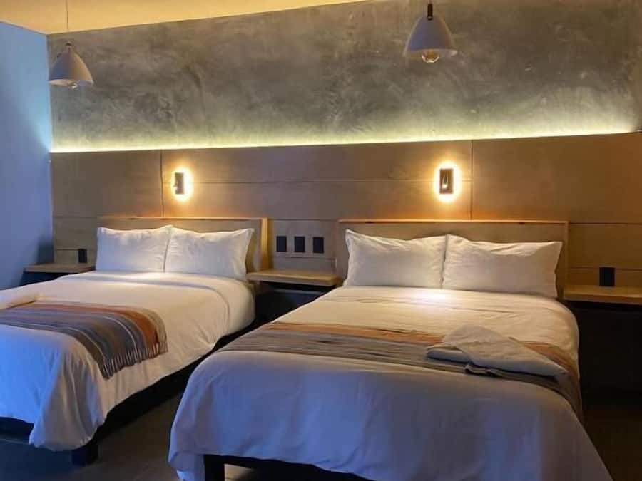 Een hotelkamer met twee bedden, een modern design en sfeerverlichting.
