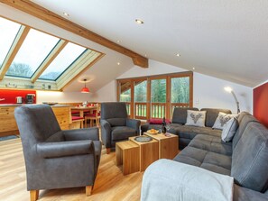 Ein geräumiger Loft mit Essbereich, einer Sofagarnitur und einer Küche mit roter Akzentwand.