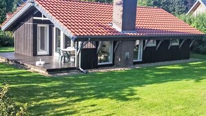 Een huis met een rood pannendak, schoorsteen en een schotelantenne.