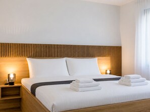 A hotel room with a bed, two bedside lamps, and a stack of towels. - Vacation home Antica by Interhome (Rab/Lopar)