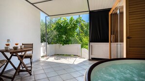 A covered outdoor area with a table, chairs, and a hot tub. - Hidden Hill by Interhome (Rab/Lopar)