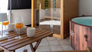 A wooden table with glasses and a bowl, a white mug, and a wooden bathtub with a logo. - Hidden Hill by Interhome (Rab/Lopar)