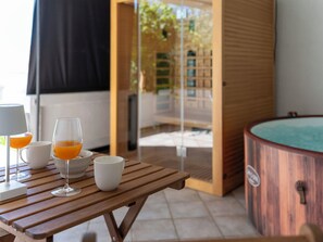 A wooden table with glasses and a bowl, a white mug, and a wooden bathtub with a logo. - Hidden Hill by Interhome (Rab/Lopar)
