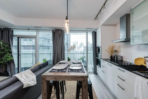 Una cocina moderna con comedor, ventanas amplias y vistas a la ciudad.