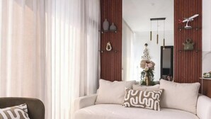 A living room with a sofa, a chair, and a large mirror. - Edificio Arles (Guatemala City)