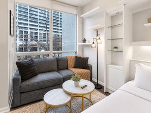A modern living room with a grey sofa, a round coffee table, and a floor lamp.