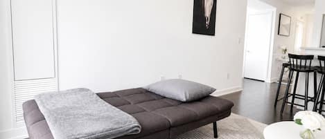 Suite Deluxe, varias camas, baño privado, vista a la ciudad | Área de sala de estar | Televisión de pantalla plana de 50 pulgadas con canales digitales