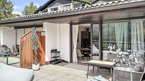Ein modernes Haus mit Terrasse, einem Esstisch und einer Sitzecke.