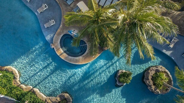 An aerial view of a resort with a central circular pool, palm trees, and lounge chairs. - WESTIN NANEA OCEAN VILLAS 2 BDRM Resort View Maui, Lahaina
May 29 – June 1, 2026 (Lahaina)