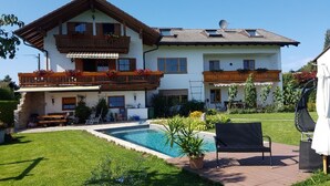 A two-story house with a swimming pool, outdoor seating, and a garden. - Vacation apartment "Wendelsteinblick" (Heufeld)