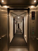 Un ascensor con pantalla digital que indica 2 personas y una capacidad de 408 kg.