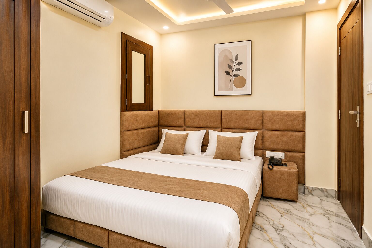Habitación de hotel con una cama grande, teléfono junto a la cama, una obra de arte enmarcada en la pared y un armario de madera.