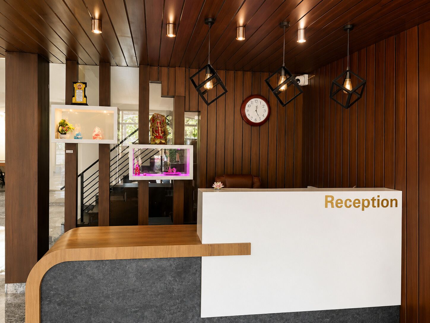 Una recepción con un reloj, paneles de madera e iluminación colgante.