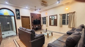 Un salon comprenant un ensemble de canapés, un téléviseur et un ventilateur de plafond.
