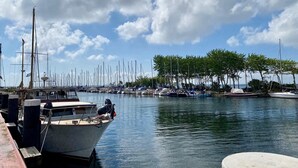 A marina with multiple boats docked, calm water, and a clear sky. - Ferienwohnung in Orth auf Fehmarn (Fehmarn)