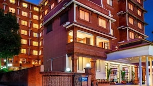 A multi-story hotel with a brick facade, multiple balconies, and a well-lit entrance. - Royal Singi Hotel (Kathmandu)