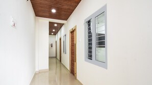 A hallway with a wooden ceiling, white walls, and a fire extinguisher mounted on the wall. - Townhouse Badangpet Crossway Hyderabad (Hyderabad)
