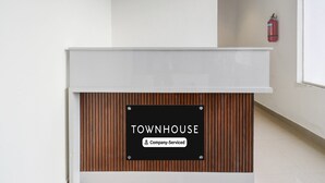 A reception desk with a sign that reads 'TOWNHOUSE Company-Serviced.' - Townhouse Badangpet Crossway Hyderabad (Hyderabad)