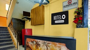 A hotel reception area with a 'HOTEL' sign, a 'NO SMOKING' sign, and a reception desk with a tropical mural. - Super Deluxe Room Hotel O Calangute Rd (Calangute)