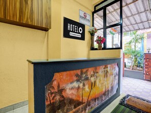 A hotel reception area with a 'HOTEL' sign, a 'NO SMOKING' sign, and a 'Company-Serviced' label.