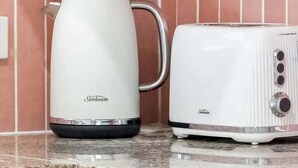 Une cuisine avec une bouilloire Sunbeam blanche et un grille-pain blanc posés sur un plan de travail.