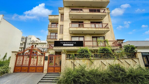 A multi-story building with a sign indicating it is a serviced company townhouse.