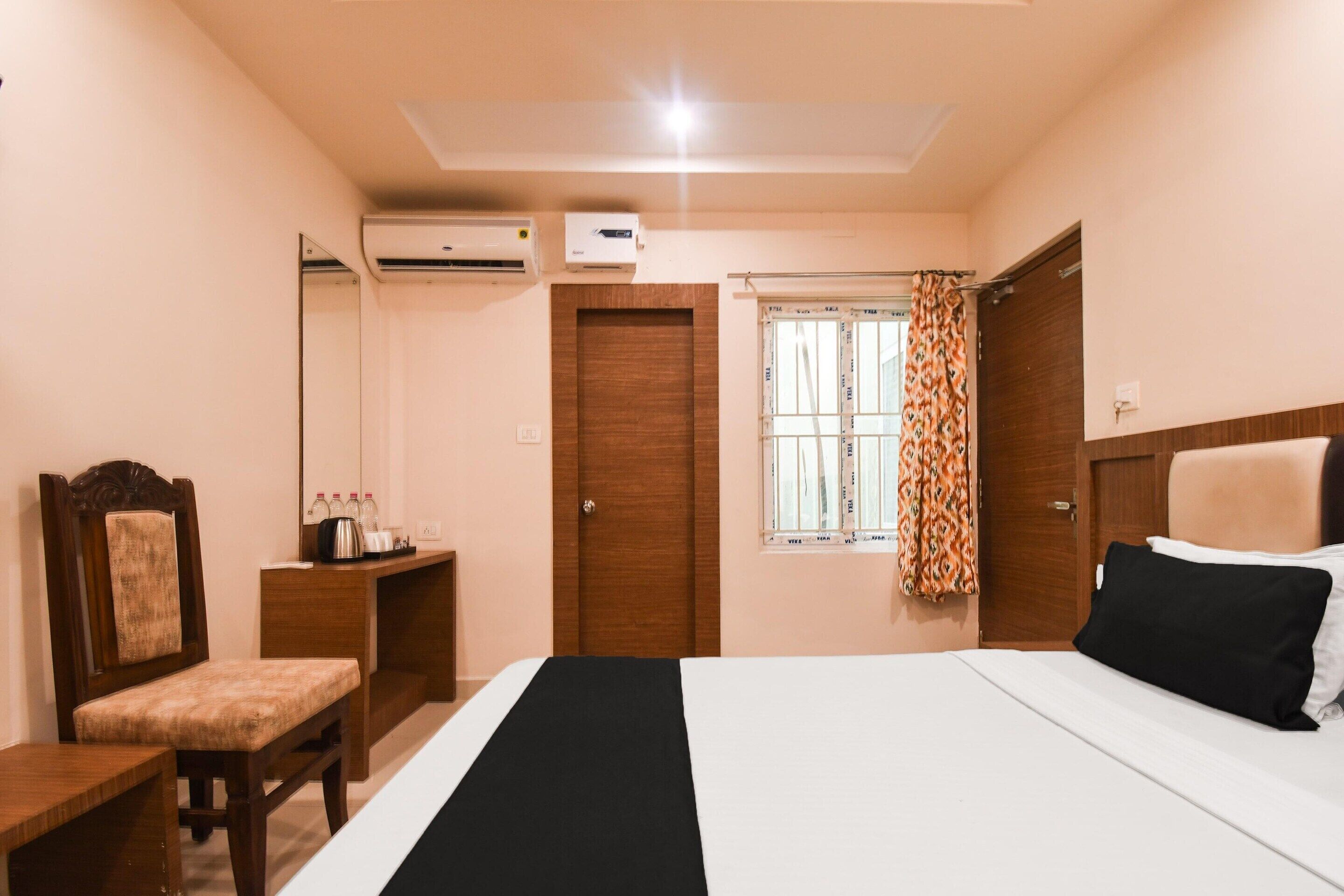 Un dormitorio con cama, escritorio, silla, armario y equipo de aire acondicionado.