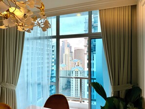 A room with a large window, curtains, a chair, and a potted plant. - Prime BGC 4BR, 153 sqm. in City Central Bgc walk to Burgos Circle & High Street (Taguig)