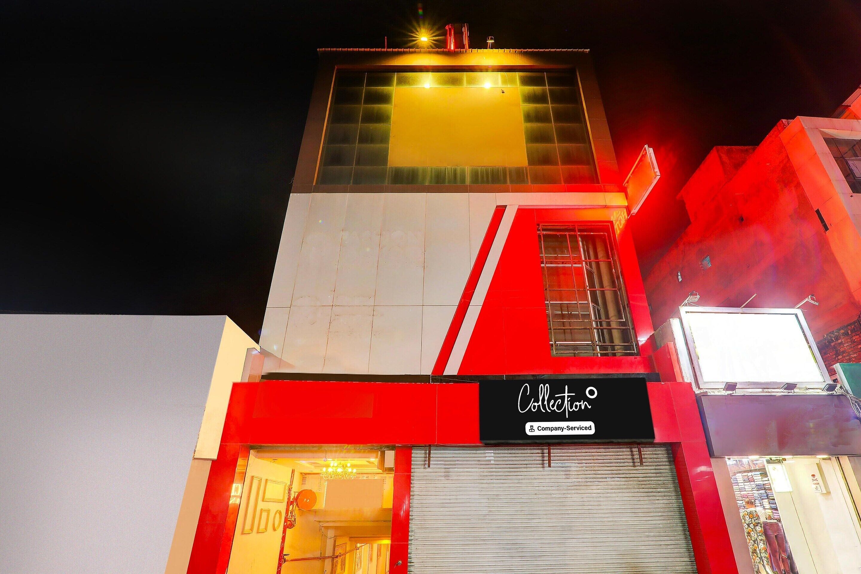 A building with a red and white facade, a visible entrance, and a sign that reads 'Collection.'