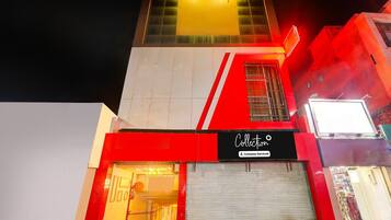 A building with a red and white facade, a visible entrance, and a sign that reads 'Collection.'