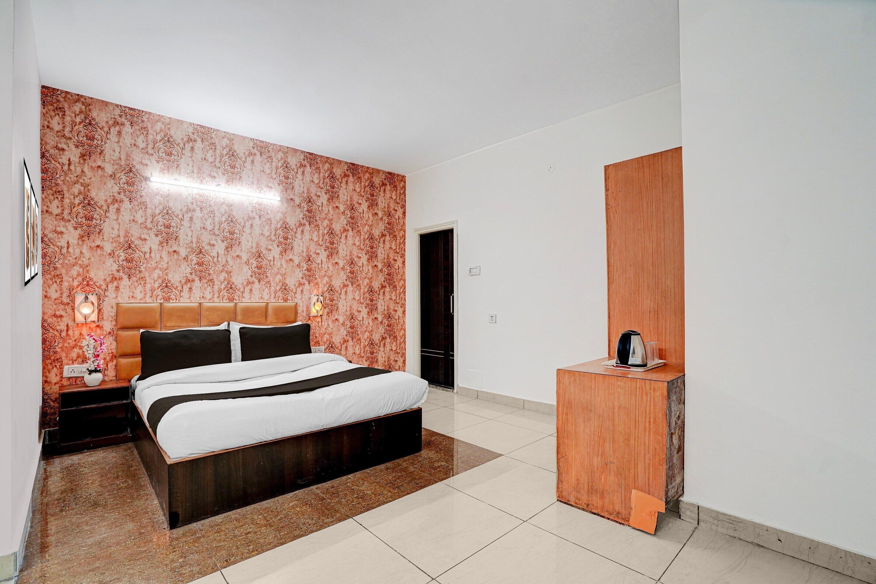 Ein modernes Hotelzimmer mit einem großen Bett, einem Holfnachtkästchen und einem Spiegel.