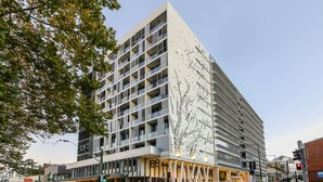 Ein modernes Mehrstöckiges Hotel mit einer markanten Fassade, großen Fenstern und einem gut sichtbaren Eingang.