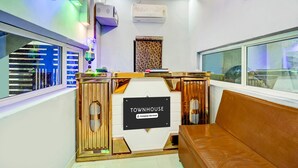 A reception area with a sign reading 'TOWNHOUSE,' a seating area, and a window with blinds. - Premium Anisabad Near Mahavir Sansthan (Patna)