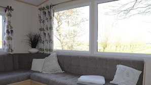 Un canapé d’angle avec un coussin, un oreiller blanc et un coussin décoratif orné de motifs textuels.