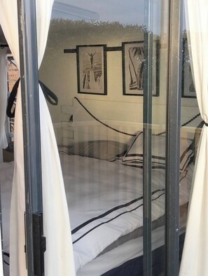 A room with a bed, curtains, and framed pictures on the wall. - The Salt Modern Coastal Escape (Franskraal)