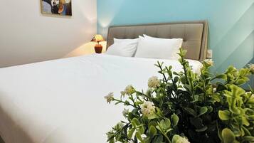 Quarto com cama, ar condicionado na parede, abajur e planta em vaso.