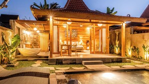 Una casa de madera con techo de tejas, piscina y un patio cubierto.