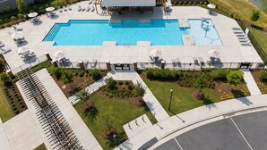 A large outdoor swimming pool with multiple lounge areas and a covered seating area. - Lux 4BR,3.5Bath townhome, perfect for groups (Cary)
