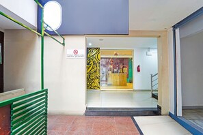 A hallway with a no-smoking sign, a patterned wall, and a fire extinguisher.