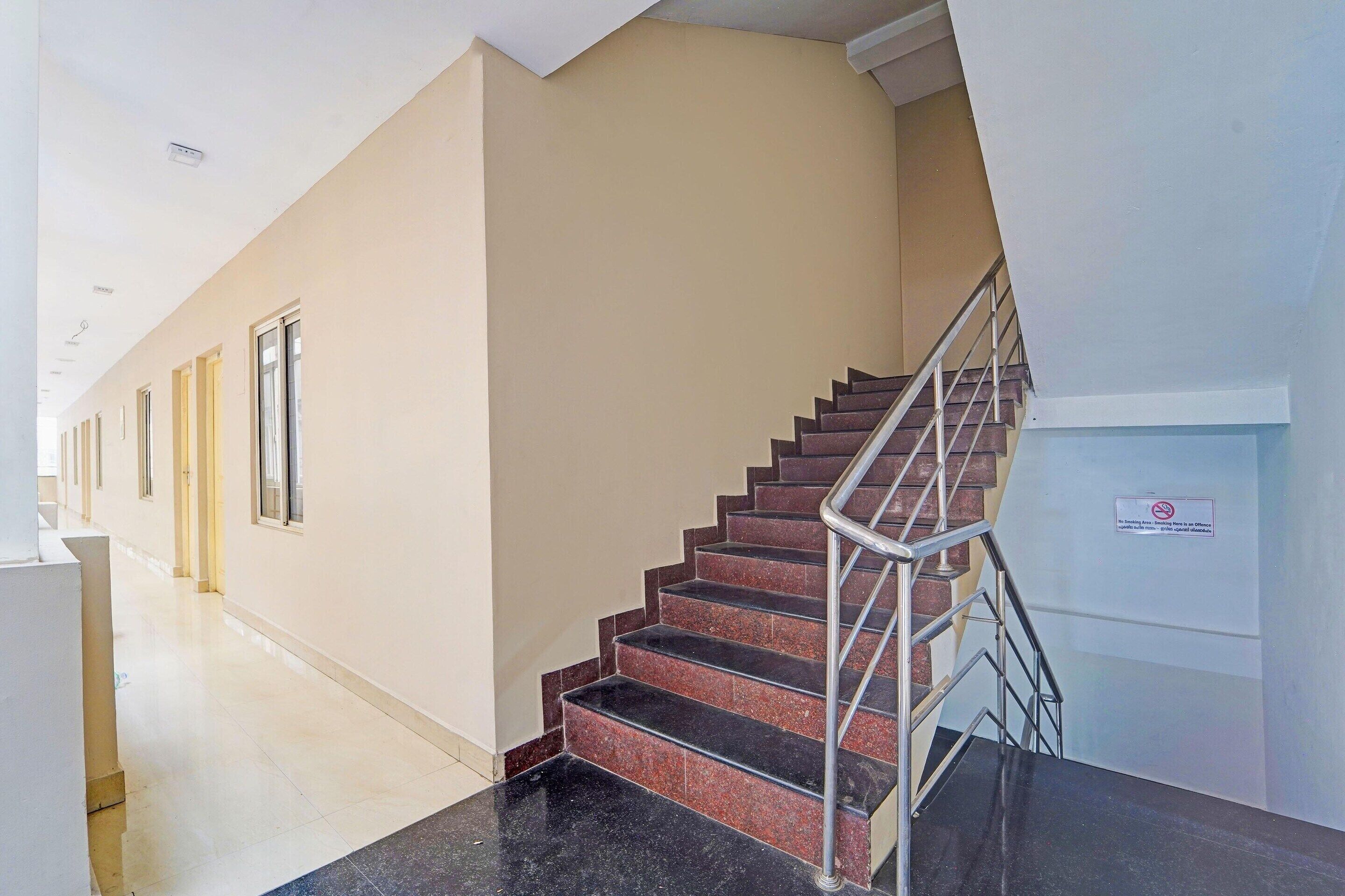 Ein Hotelgang mit Treppe, Geländer und einem Schild an der Wand.