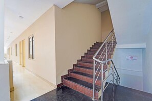A hotel corridor with a staircase, a handrail, and a sign on the wall. - Classic The Beige Hotel (Kozhenchery)
