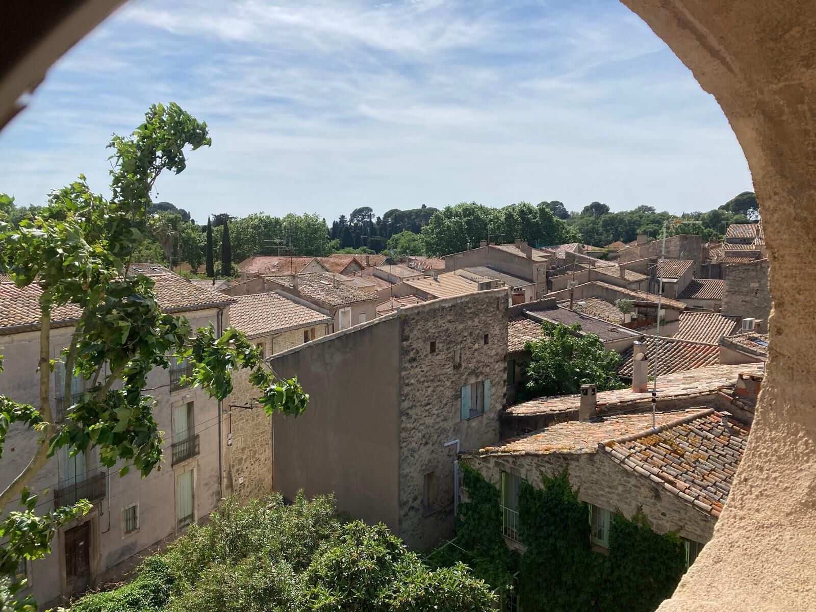 A view of a historic town with stone buildings and terracotta roofs.