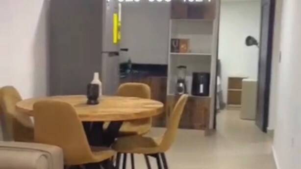 Un soggiorno moderno con un tavolino rotondo in legno, un divano e un'area pranzo con un tavolo e sedie rotonde.