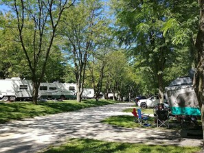 A campground with RVs parked along a gravel path, surrounded by trees. - Fish Lake Beach Camping Resort (Volo)