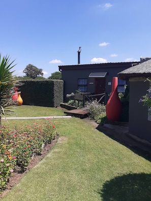 A house with a garden, a wooden deck, and a red sculpture. - Rustic Red Serene & comfortable country home (Benoni North)