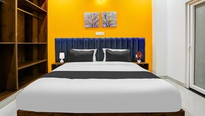 Ein Schlafzimmer mit einem Bett, einem Nachttisch, einer Wandleuchte und einer Tür.