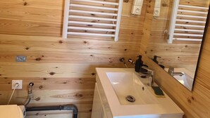 A wooden cabin bathroom with a toilet, sink, and shower. - Brand new equipped garden studio in a beautiful region near mountains and lake (Perrignier)