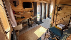 A wooden interior with a TV, a fan, a dining area, and a sofa. - Brand new equipped garden studio in a beautiful region near mountains and lake (Perrignier)